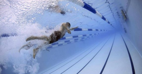 Lignes d’eau d’un bassin sportif de piscine municipale, vu depuis le bord