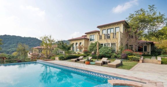 Piscine d’une résidence, entourée de bâtiments et de plantations
